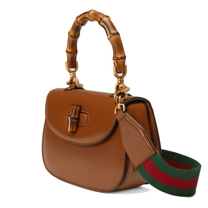 Curator examining a Gucci bag under studio lighting